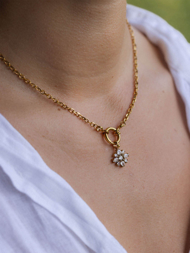 PURELEI Blossom Charm Anhänger in 18K Gold mit funkelnden Zirkonia, getragen an eleganter Kette am Hals, zeitlos schön