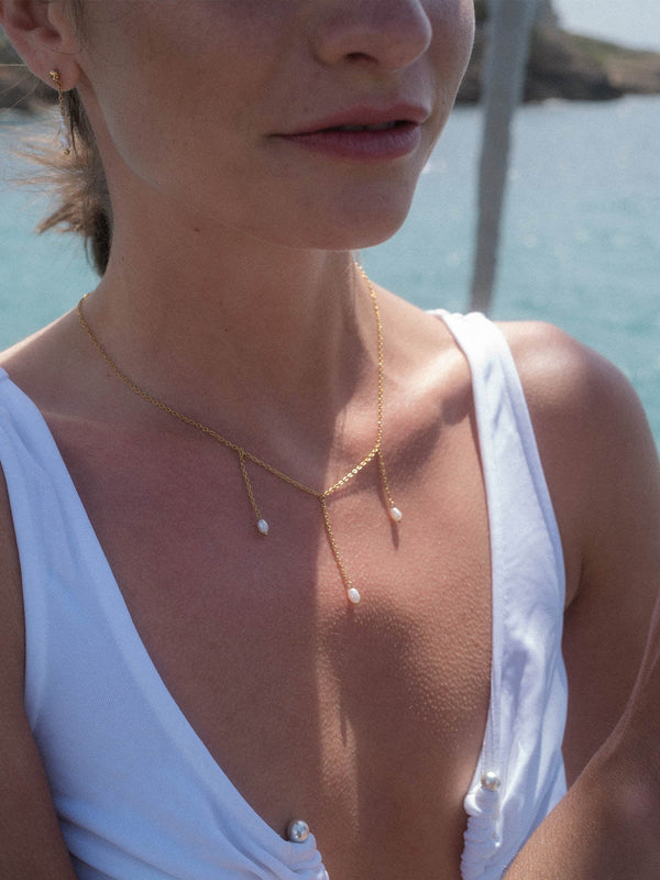 PURELEI Mahina Club Purely Kette in 18K Gold mit dreifacher Süßwasserperle, leicht und elegant am Strand getragen