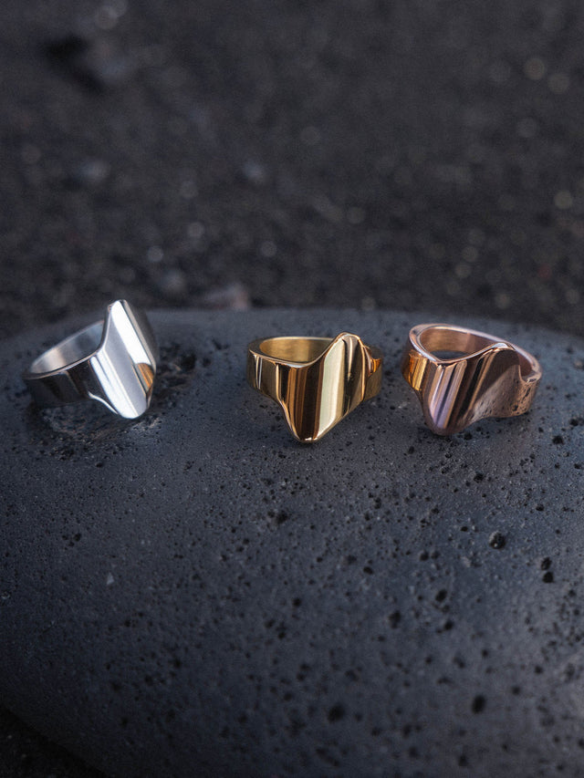 Lava Ring in Silber, Gold und Roségold, geschwungene Edelstahlringe auf schwarzem Lavastein von PURELEI.