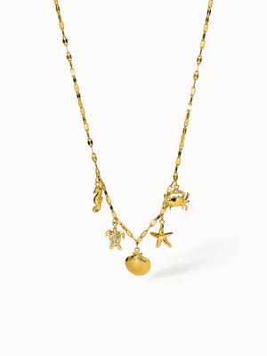 Goldene Kette mit maritimen Anhängern von PURELEI, strahlt tropische Eleganz aus.