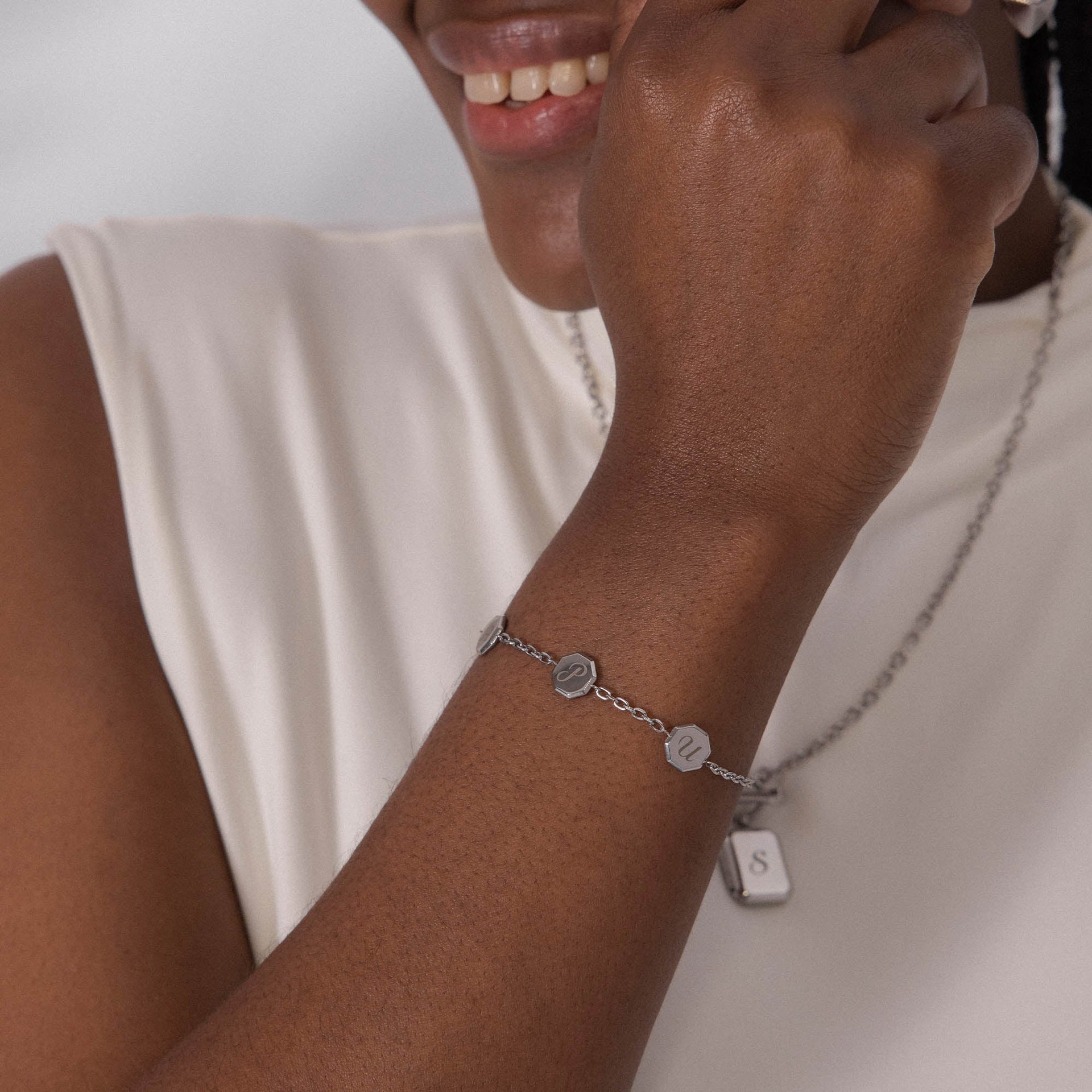 Silbernes Armband mit Buchstabenanhängern, elegant am Handgelenk getragen – PURELEI.