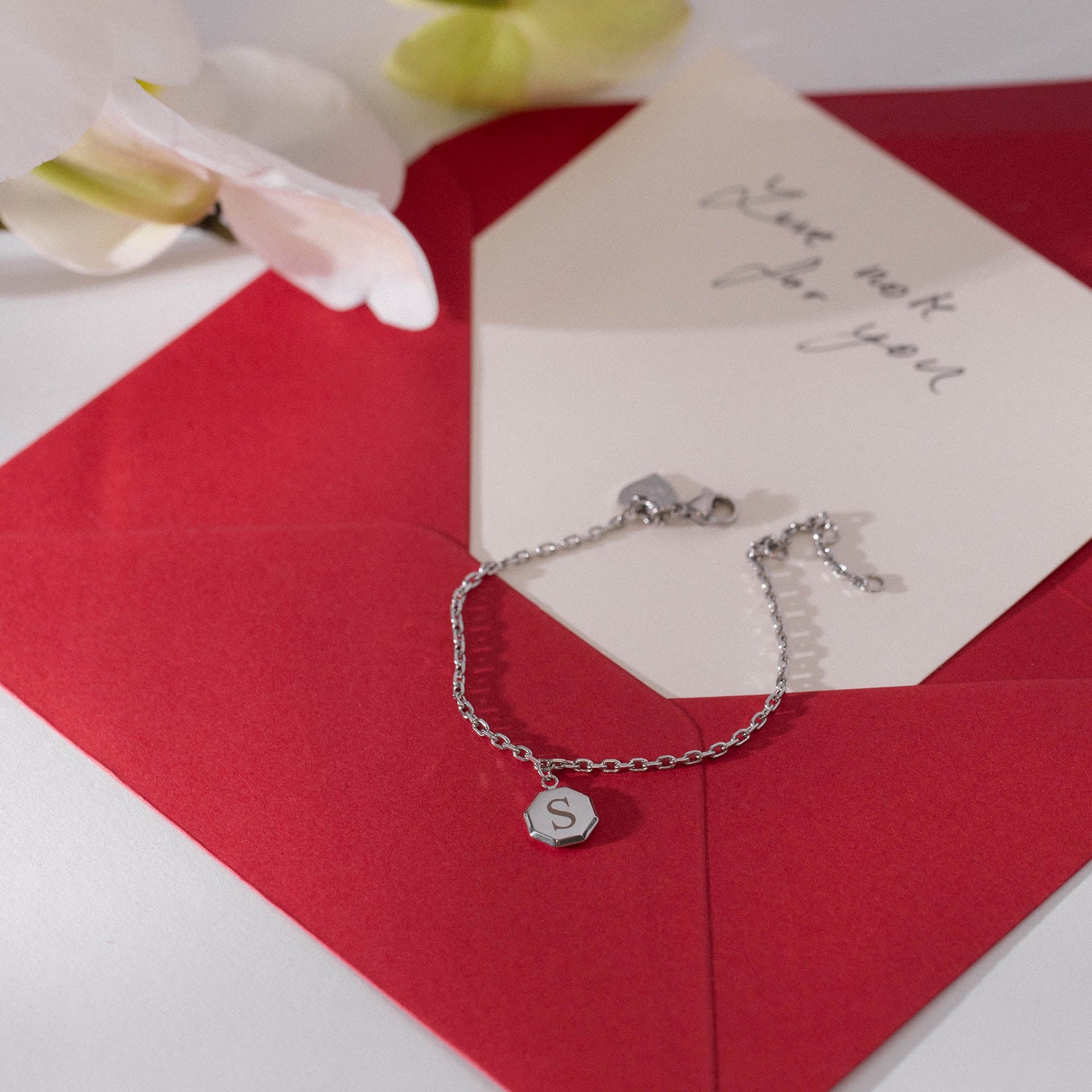 PURELEI Beloved Armband aus nickelfreiem Silber mit gravierbarem achteckigem Anhänger auf rotem Briefumschlag